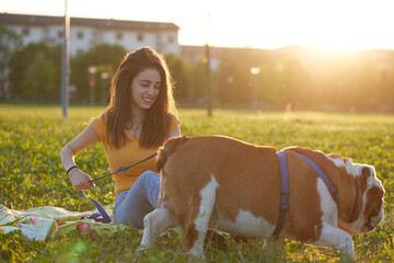 Young brunette girl play with her british bulldog