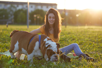 Young brunette girl play with her british bulldog