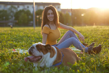 Young brunette girl play with her british bulldog