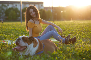 Young brunette girl play with her british bulldog