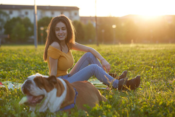 Young brunette girl play with her british bulldog