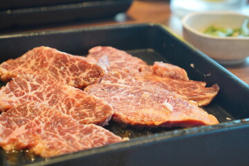 焼き台にのせる前の生肉をアップで撮影した写真。霜降り模様が美しい牛肉のカット。焼肉・バーベキュー・キャンプ飯など、食材イメージに使いやすいフード素材。
