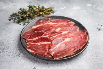Slices of prsut, Balkan pork meat ham. grey background. top view