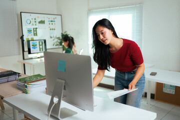 Asian woman analyzing documents at modern office workplace