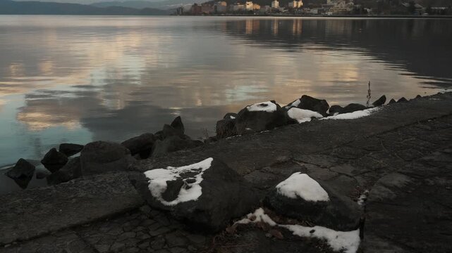 鏡面の水面とゴツゴツした岩のある晩秋の湖畔