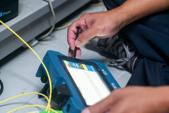 Technician Using Device for Network Troubleshooting - Powered by Adobe