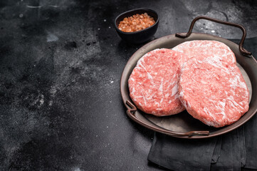Frozen Meat cutlet, mincemeat of pork and beef for burgers. black background. top view