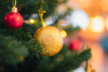 Close up Christmas tree decoration.Golden ornament ball,red sphere,lights hang pine needle.Festive holiday background,celebrate December season. Bokeh effect magic,warm,cozy atmosphere with copy space