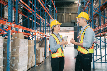 Confidence caucasian man, woman staff worker wear safety helmets, vest show teamwork collaborate, cooperation in logistics inventory operation. show success, efficiency in modern warehouse management.