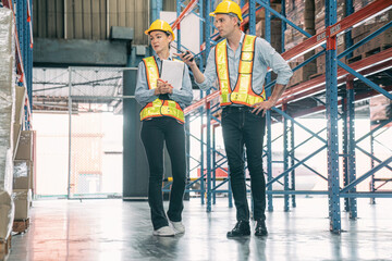 Caucasian man, woman warehouse supervisor wear safety discuss,talk and use clipboard check box package on shelf, product distribution inventory management,Logistics shipping business planning industry