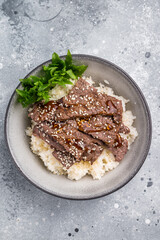 Delectable yakiniku feast, featuring a variety of marbled beef cuts and rice. A culinary journey that captures the essence of Japanese grilling traditions. grey background. top view