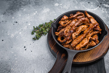 Delicious glazed teriyaki beef in a skillet. grey background. top view