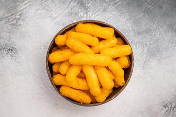 Irresistible Cheese puffs, cheese snacks bursting with bold flavors and a satisfying crunch. grey background. top view