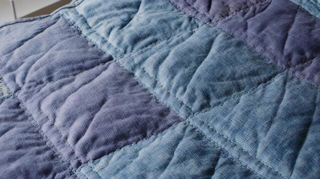 Close-up of a handcrafted quilt in shades of blue and purple