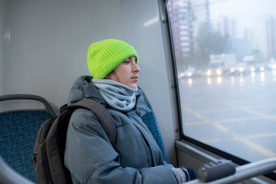 A teenage boy sits on a bus seat in winter - Powered by Adobe