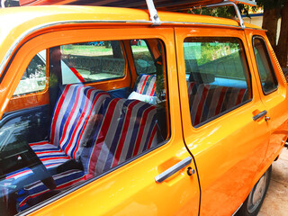 Partial side view of a vintage car, fun old design, yellow.