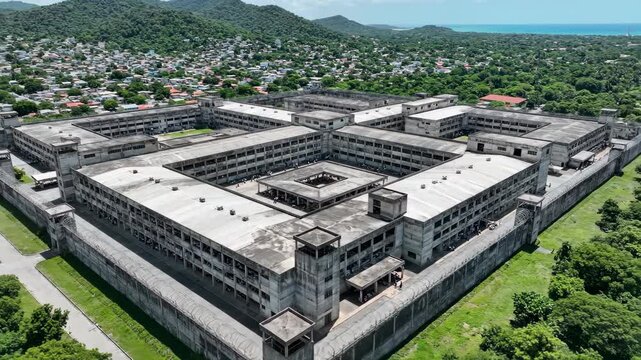 Aerial perspective of an expansive penitentiary complex nestled in a vibrant landscape