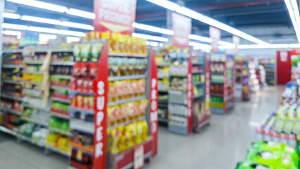 Blurred background of interior of supermarket store aisle with various products on shelves and a prominent 