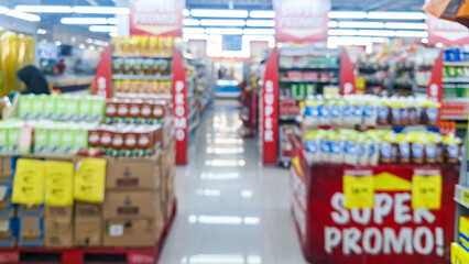 Blurred background of interior of supermarket store aisle with various products on shelves and a prominent 