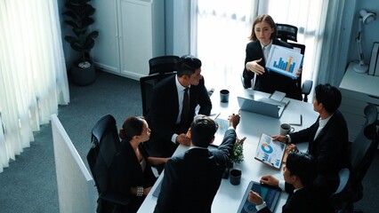 Top view of skilled project manager holds increasing stock market investment chart while businessman explains idea and present marketing strategy at meeting room. Team working together. Directorate.