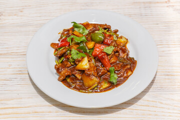 Bœuf à la sauce thaï et basilic sur assiette blanche. Cuisine thaïlandaise. Traiteur thaï.