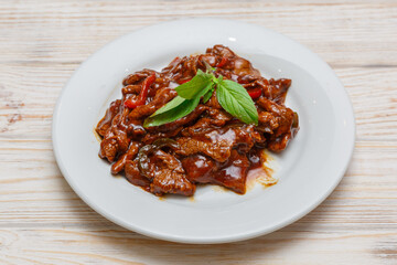 Bœuf à la sauce thaï et basilic sur assiette blanche. Cuisine thaïlandaise. Traiteur thaï.