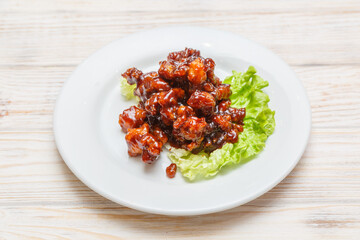 Poulet caramel sur assiette blanche. Cuisine asiatique. Traiteur asiatique.