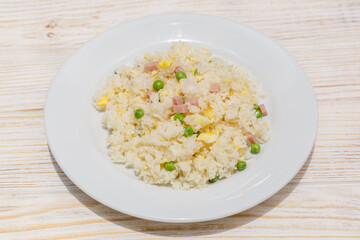 Riz cantonnais sur assiette blanche. Cuisine chinoise. Traiteur chinois.