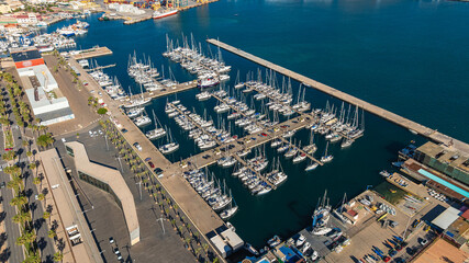 Side aerial view of seaport in Cartagena, Spain. Cruise ships and small boats moored. Travel...