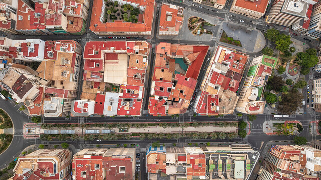 Colorful rooftops and roads. Residential areas, sidewalks, tropical plants. Drone view of Alicante, Spain