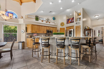 A beautiful kitchen that includes a stylish bar and several stools in it