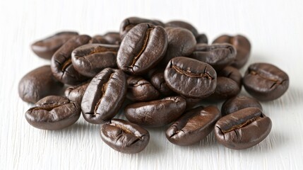 Close up image of roasted arabica coffee beans piled on a white background surface