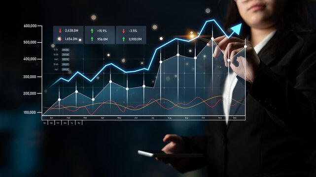 A professional businesswoman analyzes financial data through digital graphs in a modern office, focusing on trends and metrics for strategic insights and decision-making. Scalp
