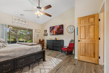 A cozy bedroom featuring a spacious large bed and a cooling ceiling fan