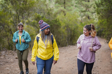 Happy group of multiracial women during hiking day in the mountains - Trekking, multi generational people and active lifestyle concept