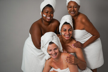 Multiracial women posing in front of camera during skin care treatment - Beauty day, multi generational people and lifestyle concept