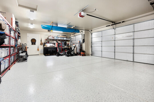An empty garage with an open door and a window for light