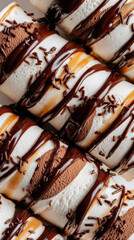 Layered ice cream rolls drizzled with chocolate and caramel sauce, topped with chocolate sprinkles on a light background