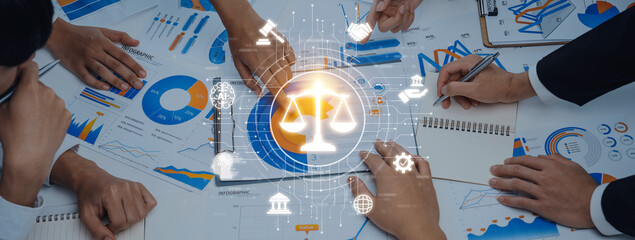 A diverse group of professionals collaborates in a business meeting, using data charts and legal symbols to enhance strategy development and decision-making processes. Trope