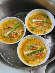 Warm bowls topped with scallion and chili slices.
