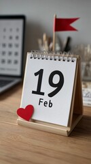 Clean desk setup featuring a calendar marked 19 Feb with a small flag and heart shape accent for office reminders and organization