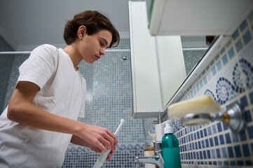 Teen Brushing Teeth in Bathroom with Toothbrush and Sink During Morning Routine