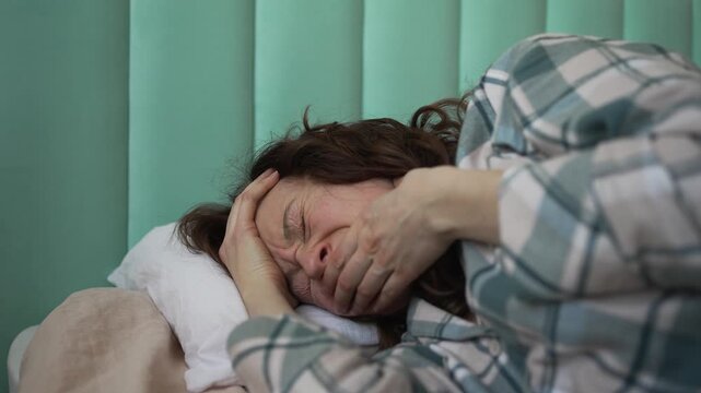 Unwell pregnant woman in pajamas lying in bed during her first trimester, experiencing severe nausea and morning sickness, feeling dizzy and ready to vomit from pregnancy toxicosis symptoms