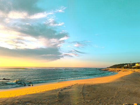 Magic empty beach at dusk. Serene golden sunset seascape with gentle waves and dramatic Sky