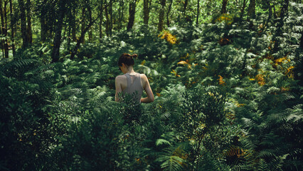 young woman walking through tall vegetation