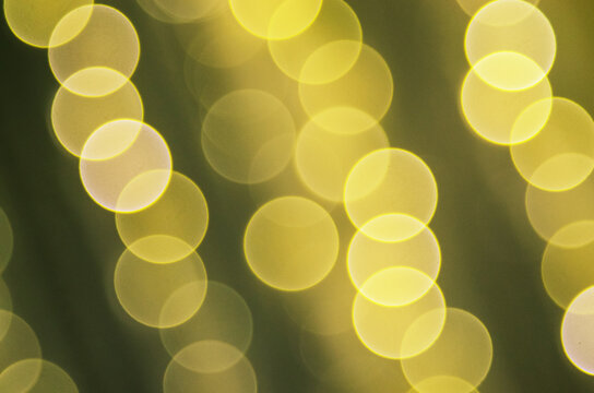 Abstract background of yellow bokeh lights on a dark green backdrop