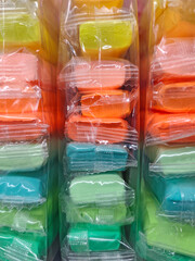 Stacks of colorful air-dry clay packs in clear plastic wrapping, arranged in rows with bright pastel shades of yellow, orange, pink, green, and blue.