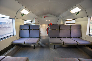 Empty commuter train interior with seats and windows
