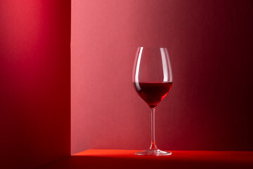 Red wine glass over red background with copy space