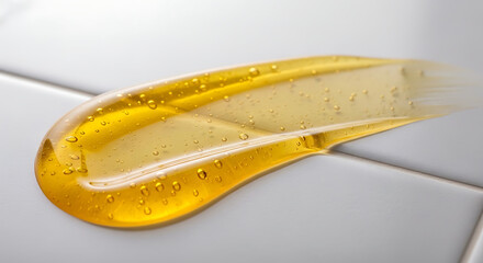 Translucent golden cosmetic gel swatch with tiny bubbles